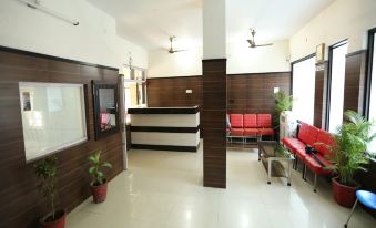 There is a lobby in an office or medical center with benches and plants in the waiting room at Bombay Picnic Spot Hotel & Resort