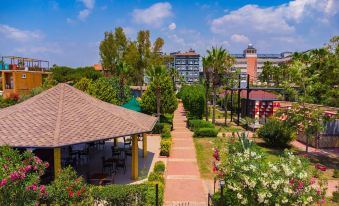 a beautiful residential area with multiple buildings , trees , and a path leading to a pavilion at Mediterranean Breeze Hotel