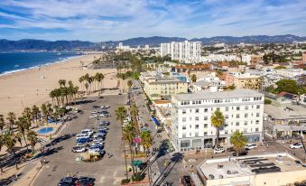 a bird 's eye view of a city with tall buildings , palm trees , and cars parked in the lot at Air Venice on the Beach
