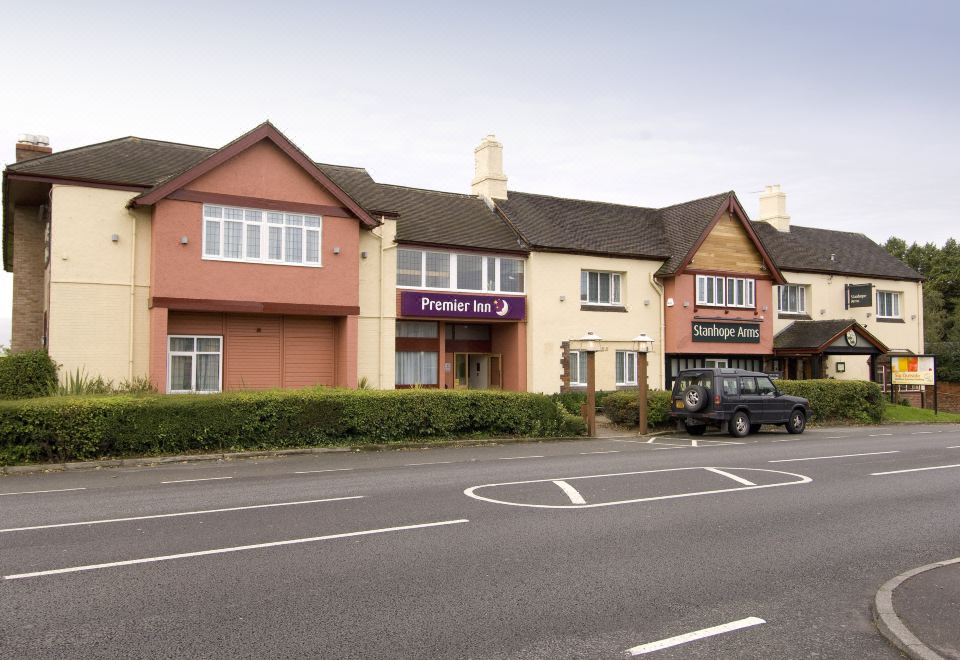 a row of houses on a street , with a car parked in front of them at Premier Inn Burton On Trent East