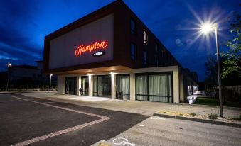 "a building with a large sign that reads "" hampton inn "" prominently displayed on the front of the building" at Hampton by Hilton Toulouse Airport