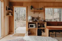 Tiny cabin amongst trees on a farm with alpacas