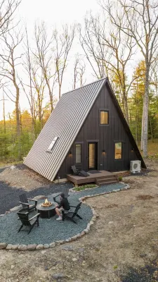 A modern A-frame, nestled in the woods with relaxing outdoor spaces and firepit.
