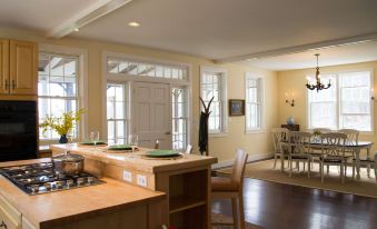 a large kitchen with a center island and wooden cabinets , as well as a dining table and chairs at Windham Hill Inn