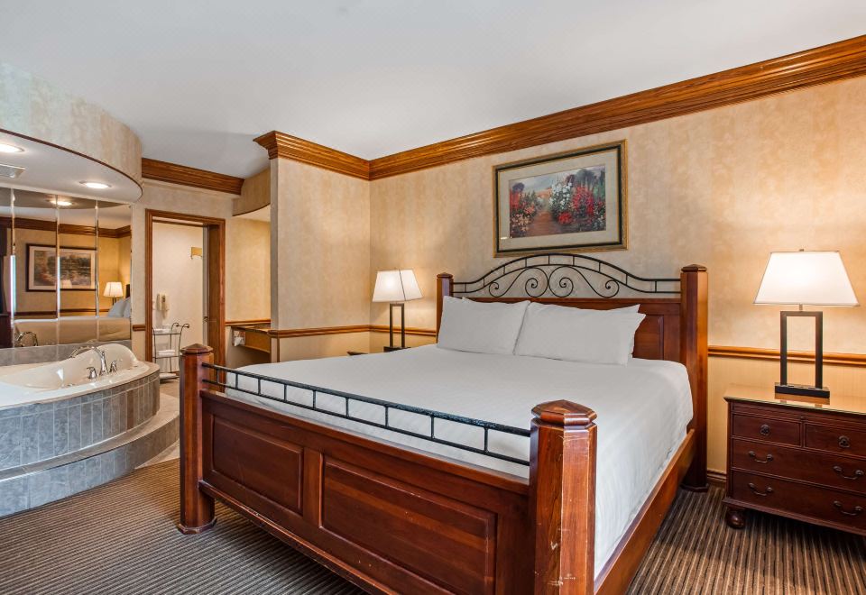 a large bed with a wooden headboard and footboard is in a room with beige walls at Best Western Parkway Inn  Conference Centre
