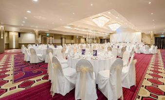 a large banquet hall with multiple tables set up for a formal event , possibly a wedding reception at Hillgrove Hotel, Leisure & Spa