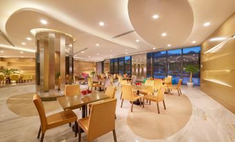 a modern dining room with multiple tables and chairs , some of which are occupied by people at Holiday Inn Express