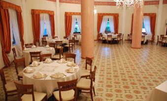 a large , elegant dining room with multiple tables and chairs arranged for a formal event at Eden Park Hotel