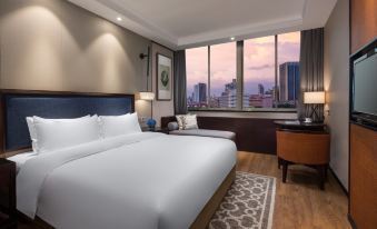 The bedroom, with large windows offering city views, is located next to a white bed at Kasion Purey Hotel (Yiwu International Trade City store)