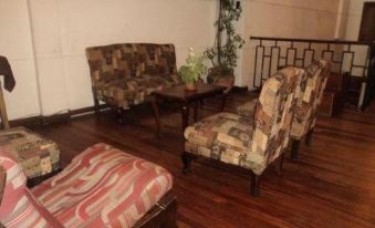a living room with wooden flooring , furniture , and plants , including couches , chairs , and a coffee table at Copacabana