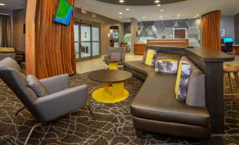 a modern hotel lobby with various seating options , including couches , chairs , and a coffee table at SpringHill Suites Centreville Chantilly