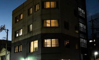 a building with many windows is lit up at night , and a car is parked in front of it at Volcano