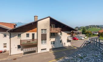 a large , two - story building with a sloping roof and balconies is situated on a street at Annex