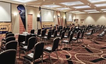 a conference room with rows of chairs arranged in a semicircle , ready for a meeting or presentation at Novotel Swan Valley Vines Resort