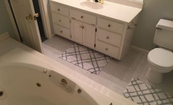 a bathroom with a bathtub and a sink , along with a mirror above the sink at The Waterford