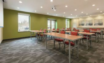 a large conference room with multiple rows of tables and chairs arranged for a meeting at Home2 Suites by Hilton Williamsville Buffalo Airport