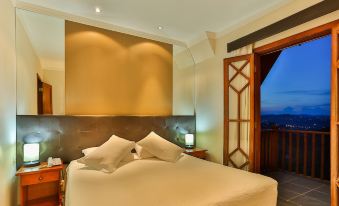 a bedroom with a large bed , a lamp on the nightstand , and a door leading to a balcony at Hotel Home Green Home
