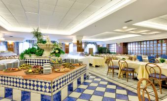 a large dining room with a buffet table filled with various food items , including fruits and vegetables at Hotel Antares