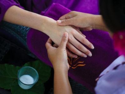 a woman is getting a hand massage from another person while sitting on a chair at Vilamendhoo Island Resort & Spa