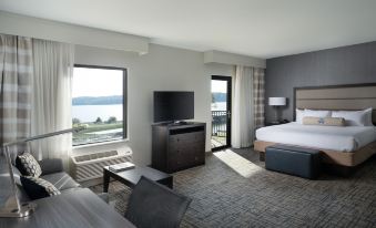 a hotel room with a king - sized bed , a flat - screen tv , and a view of the water at Shangri-La Resort