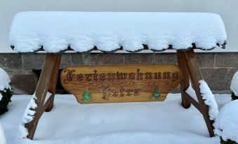 "a wooden sign with the words "" kernbuchtmaß "" ( king 's foot ) written on it , surrounded by snow" at Petra