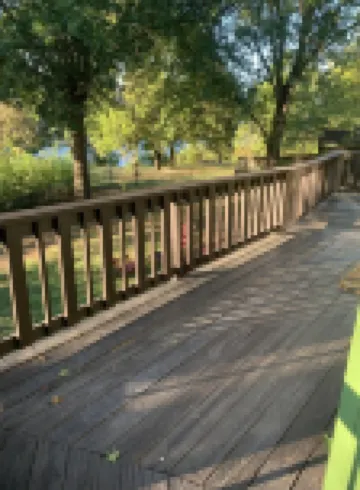 Lakeside house with fireplace, deck, and a fenced backyard with firepit.