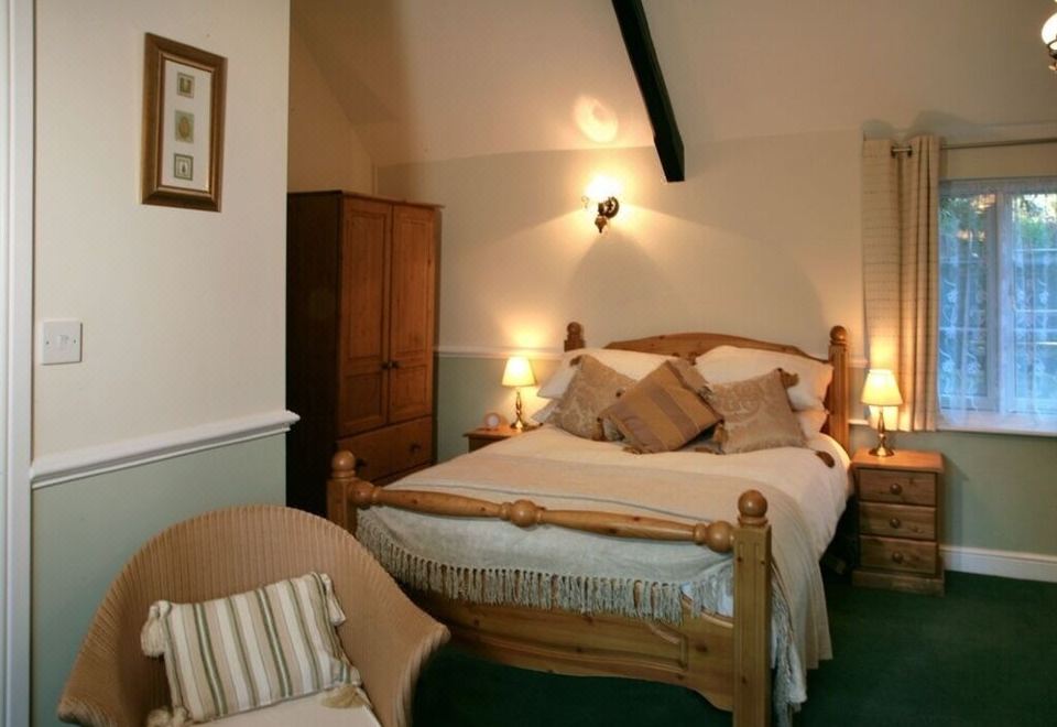 a cozy bedroom with a wooden bed , two nightstands , and a lamp on each side of the bed at The Bell Inn