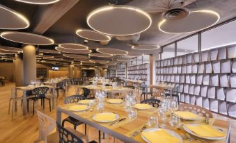 a modern , well - lit dining room with multiple tables and chairs set up for a meal at The Gate Hotel