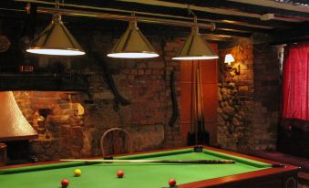 a pool table with a green felt surface and three red balls in the center at The Barford Inn