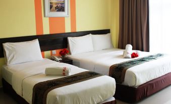 a hotel room with two beds , one on the left and one on the right side of the room at Sun Inns Hotel Kuala Selangor