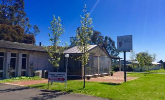 a basketball court is located in front of a building with a sign on it at Manjimup Kingsley Motel