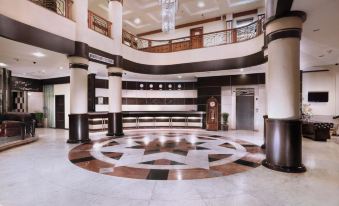 a large , well - lit lobby with high ceilings , marble floors , and a circular design in the center at Aston Karimun City Hotel