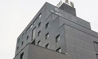 "a large building with a sign that reads "" the empress "" prominently displayed on the side" at The Empress Hotel