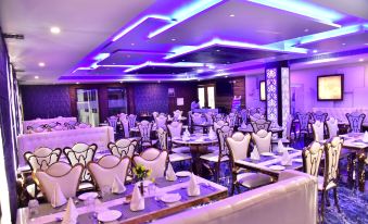 a well - lit banquet hall with multiple dining tables and chairs arranged for a formal event at The Riverside Inn