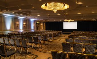 a large conference room with rows of chairs arranged in a semicircle , ready for an event at Druids Glen Resort