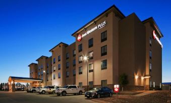a large hotel with a parking lot in front of it , illuminated at night at Best Western Plus Williston Hotel  Suites