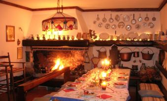 a dining room with a table set for a meal , surrounded by candles and fireplaces at Villa Margherita