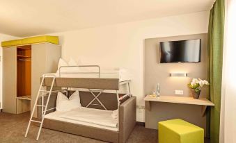 a modern living room with a bunk bed , white walls , and a yellow side table at Highway Hotel