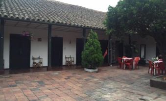 a courtyard with a brick floor and several tables and chairs , creating a cozy atmosphere at Hotel San Cristobal