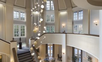 a grand staircase with a chandelier hanging from the ceiling , leading up to a second floor at Lafayette Park Hotel & Spa