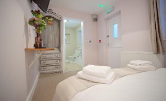 a bedroom with a large bed , white towels , and a vase of flowers on the nightstand at The Anchor Inn