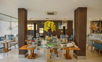 a dining room with a large table filled with various food items , including fruits and desserts at Lake View Hotel