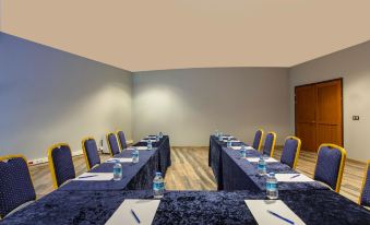 a conference room with several chairs arranged in a semicircle , and a table in the middle of the room at Aquaworld Belek