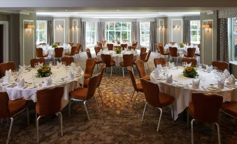 a large dining room with multiple round tables and chairs , all set for a formal event at The Bull