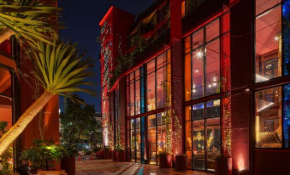 In the city at night, there is a building with lights and an illuminated clock tower at MeStyle Museum Hotel