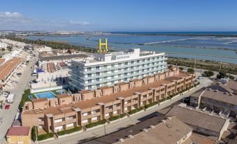 aerial view of a hotel surrounded by a body of water , with a dock visible in the distance at Hotel Lodomar Spa & Talasoterapia