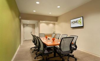 a conference room with a large table , chairs , and a television mounted on the wall at Home2 Suites by Hilton Pittsburgh/McCandless