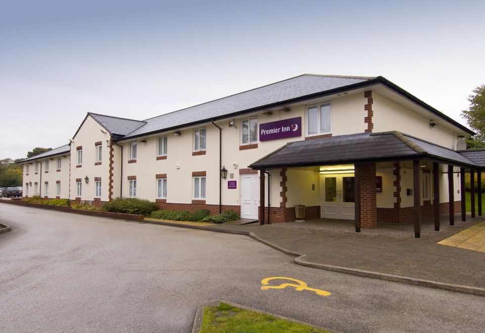 an exterior view of a two - story building with a parking lot in front of it at Premier Inn Northwich (Sandiway)