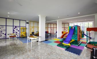 an indoor play area with a variety of colorful toys , including a slide , swings , and a jungle gym at Hotel San Isidro