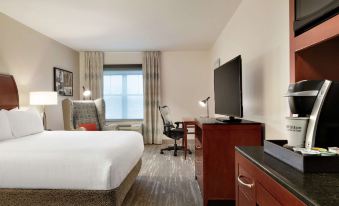 a hotel room with a king - sized bed , a flat - screen tv , a desk , and a chair at Hilton Garden Inn Troy